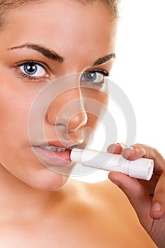 Portrait of a woman applying lip gloss