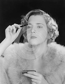 Portrait of woman applying makeup
