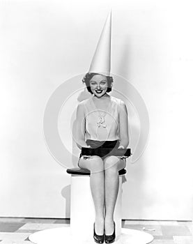 Portrait of woman with April Fool sign wearing dunce cap