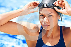 Portrait, woman and athlete swimming with goggles for challenge, water sports and training. Serious swimmer at pool in