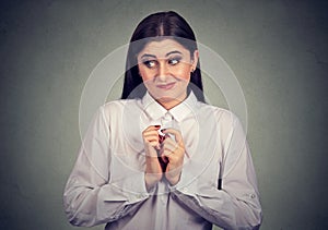 Portrait of a woman in awkward situation, playing nervously with hands.