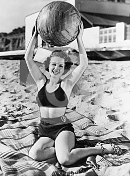 Portrait of woman with ball at beach