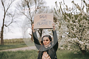 Portrait of cute woman with a banner with the slogan Save the Planet.