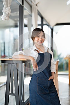 Portrait of woman barista startup successful small Asian business owner in coffee shop.Asian woman barista cafe owner