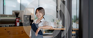 Portrait of woman barista startup successful small Asian business owner in coffee shop.Asian woman barista cafe owner