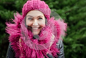 Portrait of a woman. Beautiful fashionable woman in the street. Beautiful and cheerful girl in a pink hat and pink fur scarf.