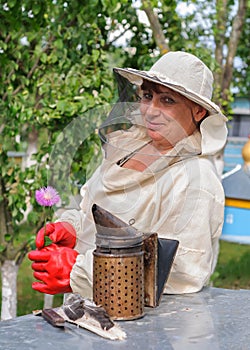 Portrait of a woman beekeeper with flower