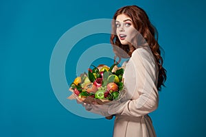 portrait of a woman beige coat fruit bouquet in hands colorful background