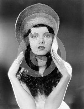 Portrait of woman bending edges of hat