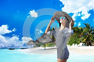 Portrait of a woman in the big hat at the tropical beach