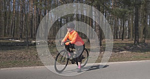 Portrait of woman on bike. Female cyclist in helmet with bicycle in forest. Triathlete preparing for training outdoor. Cycling and