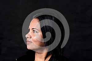 Portrait of a woman on black background, side wiew