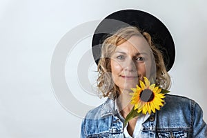 Portrait of a woman with black hat and yellow sunflower