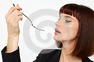 portrait of a woman in a black jacket a knife and a fork near the face  background