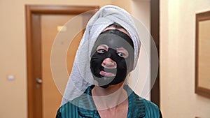 Portrait of woman with black mask on face, towel on head in hotel, flirts, hints
