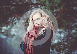 Portrait of a woman with blond curly hair on the background of the winter forest