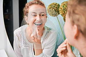 Portrait of woman with braces demonstrating interdental brushing