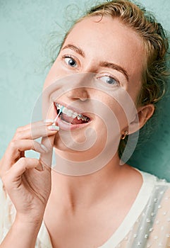 Portrait of woman with braces demonstrating interdental brushing