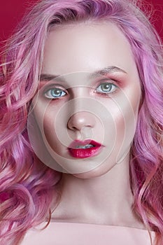 Portrait of a woman with bright colored flying hair, all shades of pink purple. Hair coloring, beautiful lips and makeup. Hair