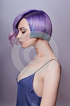 Portrait of a woman with bright colored flying hair, all shades of purple. Hair coloring, beautiful lips and makeup. Hair