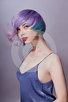 Portrait of a woman with bright colored flying hair, all shades of purple. Hair coloring, beautiful lips and makeup. Hair
