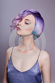 Portrait of a woman with bright colored flying hair, all shades of purple. Hair coloring, beautiful lips and makeup. Hair