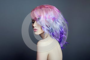 Portrait of a woman with bright colored flying hair, all shades of purple. Hair coloring, beautiful lips and makeup. Hair