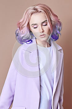 Portrait of a woman with bright colored flying hair, all shades of purple. Hair coloring, beautiful lips and makeup. Hair