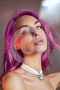 Portrait of a woman with bright colored flying hair, all shades of purple. Hair coloring, beautiful lips and makeup. Hair