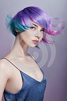Portrait woman with bright colored flying hair, all shades of purple. Hair coloring, beautiful lips and makeup. Hair fluttering
