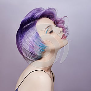 Portrait of a woman with bright colored flying hair, all shades of purple. Hair coloring, beautiful lips makeup. Hair fluttering
