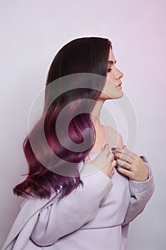 Portrait of a woman with bright colored flying hair, all shades of purple. Shiny Healthy colored Hair coloring, beautiful lips and