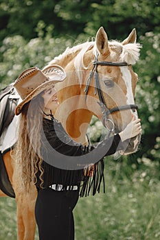 Portrait of woman in brown leather hat with a horse