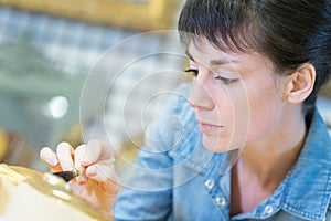 Portrait woman brushing golden gild photo