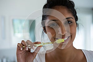 Portrait of woman brushing teeth
