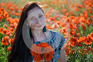 Portrait of woman with bunch of poppies