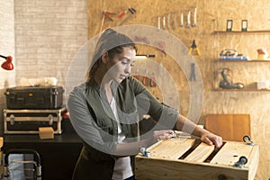 Portrait of woman in carpenter workshop with wooden tool box