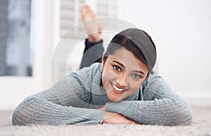 Portrait of woman on carpet with smile, relax and weekend break to unwind in living room at house. Face of girl lying on