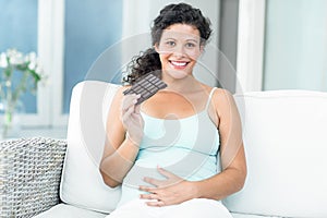 Portrait of woman with chocolate bar on sofa