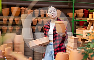 Portrait of woman choosing pots for flowers in gardening market