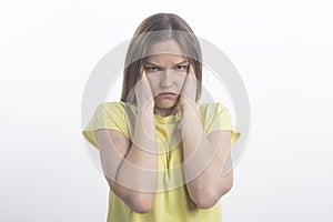Portrait of woman covering ears with hands against white background