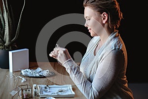 Portrait of woman, creating wedding jewelry, workplace of decorator. Woman`s hands in a process of creation