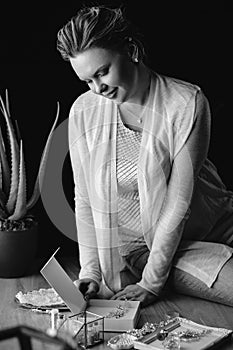 Portrait of woman, creating wedding jewelry, workplace of decorator. Woman`s hands in a process of creation