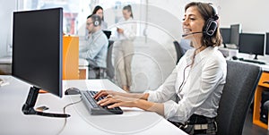 Portrait of woman customer service worker, call center smiling operator with phone headset using computer at office