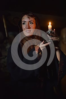 Portrait of a woman in the dark with a candle