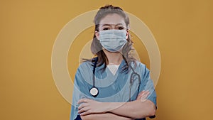 Portrait of woman doctor with arms crossed posing confident wearing covid protection and stethoscope