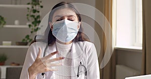 Portrait of woman doctor confident nurse or medical university student wears surgical mask on her face, sits at table