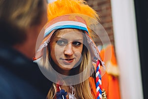 Portrait of woman dressed in orange, crazy hat, King`s Day festivity in the Netherlands