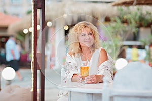 Portrait of woman drinking beer at beach cafe