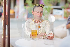 Portrait of woman drinking beer at beach cafe